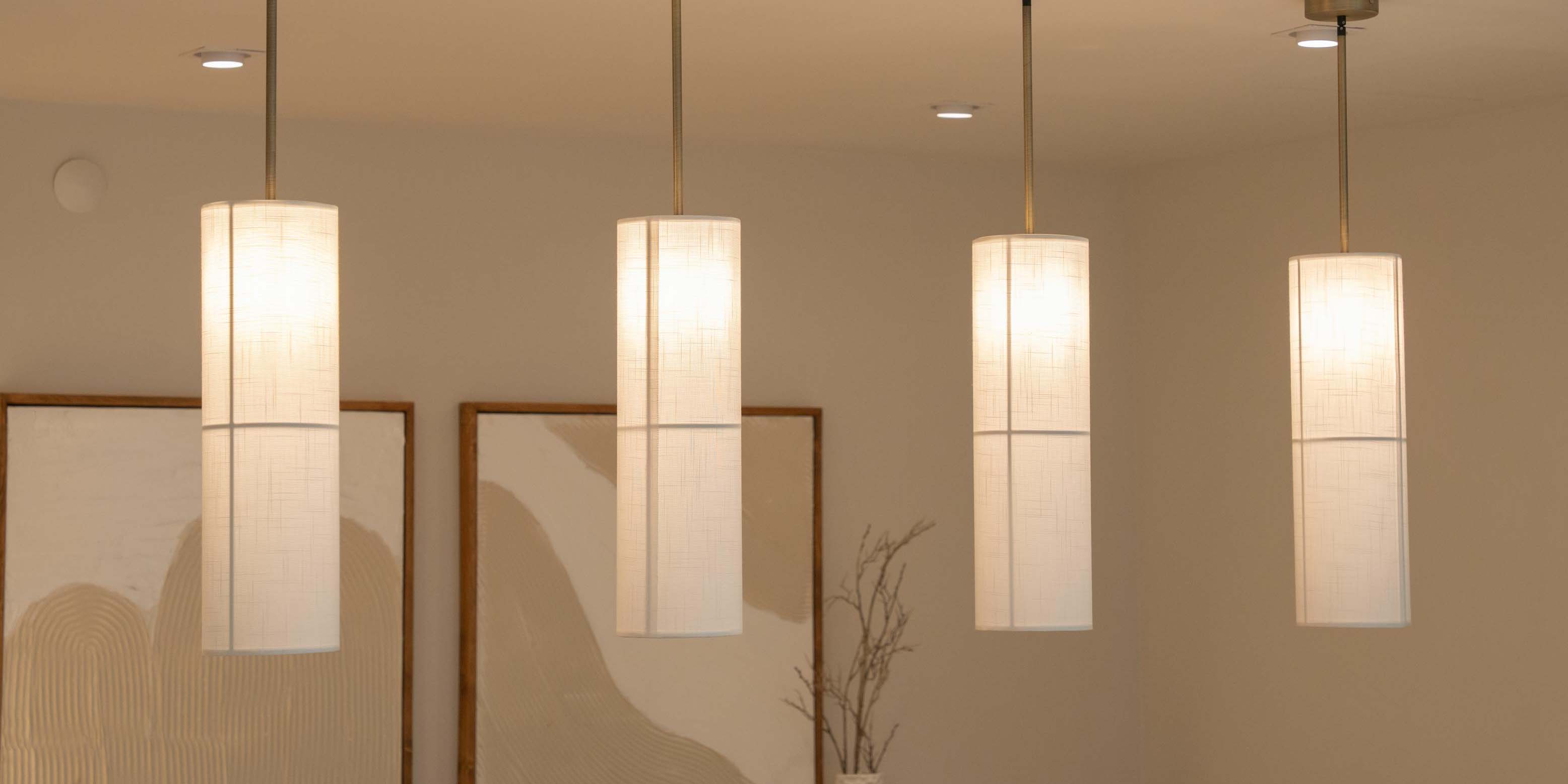 Elegant dining area with a modern chandelier, table lamps, and framed artwork, creating a sophisticated and cozy atmosphere.