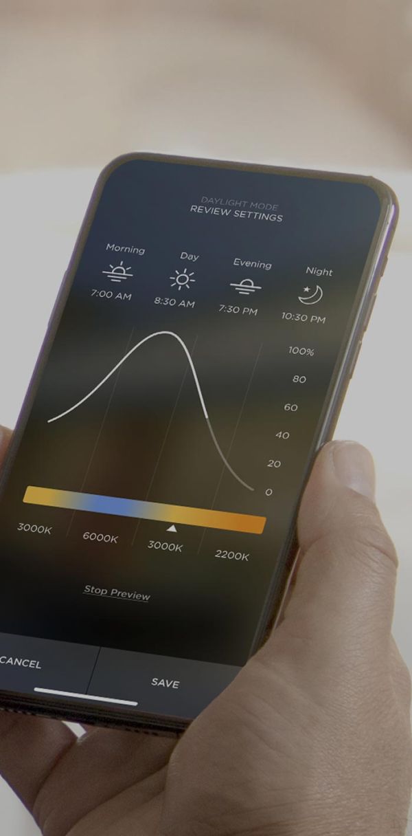 A modern glass-walled home illuminated at night with warm interior lighting, contrasting against the dark blue evening sky, showcasing a blend of ambient and accent lighting.